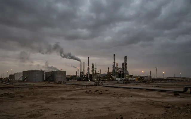 Instalación petrolera en Medio Oriente bajo un cielo nublado, representando la tensión geopolítica y el impacto económico global.